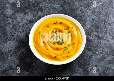 Kürbismus in einer Schüssel auf dunklem Steingrund. Gesunde Ernährung Ernährung Konzept. Nahaufnahme Stockfoto