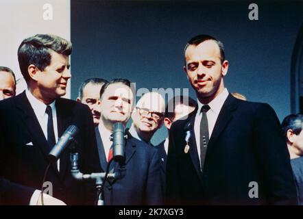 Präsident John F. Kennedy überreicht den Astronauten Alan B. Shepard Jr. bei einer Zeremonie im Rosengarten am 8. Mai 1961 im Weißen Haus mit dem Distinguished Service Medal Award der NASA. Vizepräsident Lyndon B. Johnson, NASA-Administrator James E. Webb und mehrere NASA-Astronauten stehen im Hintergrund. Nur drei Wochen später würde Kennedy Amerika verpflichten, vor dem Ende des Jahrzehnts einen Mann auf dem Mond zu landen. Bild: NASA Stockfoto