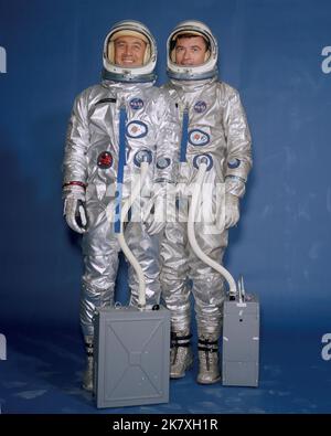 Die Gemini III Crew-Mitglieder Virgil I. 'Gus' Grissom (links) und John W. Young tragen ihre Raumanzüge, Helme und tragbaren Klimaanlagen. Stockfoto