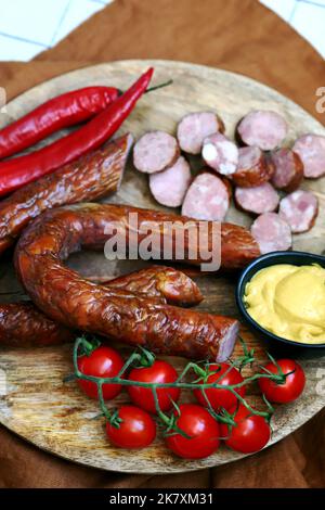 Frische hausgemachte Würstchen auf einem Holztablett Stockfoto