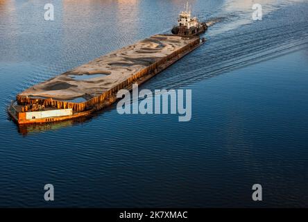 Schlepper schieben Barge mit Sand Stockfoto