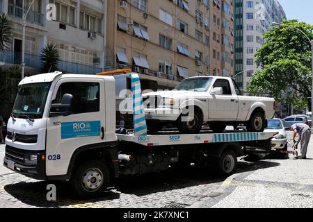 Abschleppwagen schleppen beschlagnahmt Fahrzeuge für Verkehrsverstöße. Illegales Parken, Bestrafung und Geldstrafe für unregelmäßiges Fahren Stockfoto