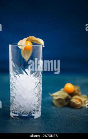 Cocktail mit Physalis alkekengi im Hintergrund gegossen und garnieren Stockfoto