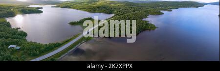 Luftbild der Bergstraße nach Norwegen mit Brücke, Berghütten, stilles See Stockfoto