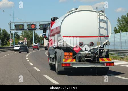 Tankwagen fährt schnell mit fossilen Brennstoffen auf der verkehrsreichen Straße Stockfoto