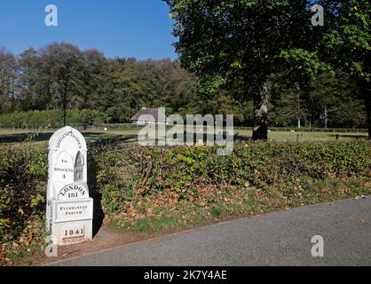 Meilenstein und Blick über Felder mit Schafen, St Fagans Museum of History, Cardiff. Abernodwydd Fachwerkhaus mit Reetgedeckten. Herbst 2022. Oktober. Stockfoto