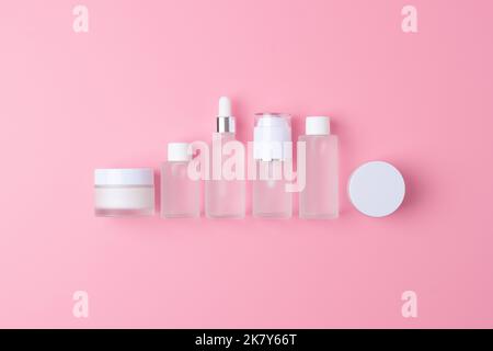 Hautpflegeprodukte auf rosa Hintergrund. Flach legen, Zusammensetzung. Stockfoto