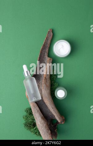 Hautpflegeprodukte auf grünem Hintergrund mit Moos, Holz. Flach liegend. Stockfoto
