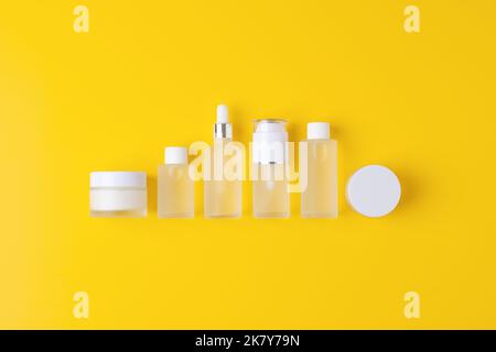 Hautpflegeprodukte auf gelbem Hintergrund. Flach legen, Zusammensetzung. Stockfoto