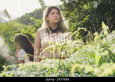 Schöne junge Latina Frau mit gefärbten blonden Haaren, einen Spaziergang in den Bergen zu entspannen und zu reflektieren. Nachdenkliche Mädchen wandern und beobachten, wie schön Stockfoto