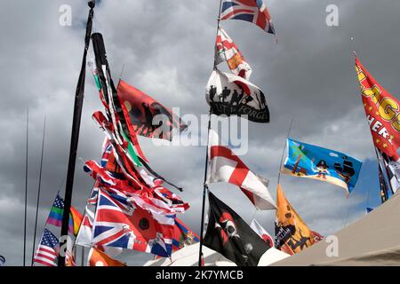 Verschiedene Flaggen fliegen gegen den blauen Himmel auf der jährlichen Reisemobilschau Great Malvern, Worcestershire, 2022, England Stockfoto