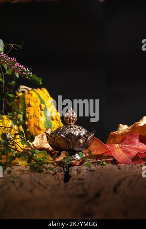 Räucherstäbchen in einer Szene verbrennen natürliche und hölzerne Dekorationsoobjekte mit schwarzem Hintergrund. Stockfoto