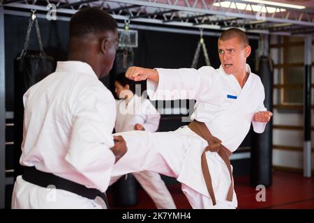 Männer, die während des Karate-Trainings Sparring machen Stockfoto