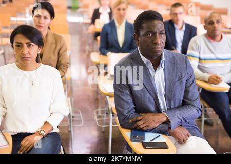 Fokussierter Mann, der Vortrag auf der Konferenz hört Stockfoto