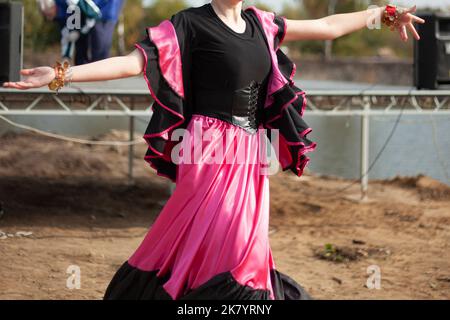 Gipsy tanzt in hellen Kleidern. Mädchen tanzen auf der Straße spanischen Tanz. In leuchtender Qualität. Tanzbewegungen. Stockfoto