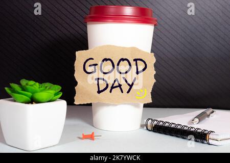 Guten Tag Inschrift Guten Tag in einer Tasse Kaffee und Holz Hintergrund. Stockfoto