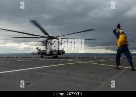 Ryan Akerson, ein Bootsmann auf der U.S.N.S Sacagawea, leitet eine CH-53E Super Henglion Marine Heavy Helicopter Squadron 361, Marine Aircraft Group 16, 3. Marine Aircraft Wing, auf das Landedeck des United States Naval Ship Sacagawea im Kushiro Port, Japan, 8. Oktober 2022. Die U.S.N.S Sacagawea dient als Kommandooperationszentrum für das Combat Logistics Regiment 37 und bietet logistische Unterstützung für verschiedene Einheiten, die an Resolute Dragon teilnehmen. Resolute Dragon 22 ist eine jährliche Übung zur Stärkung der Verteidigungsfähigkeit des US-japanischen Bündnisses durch die Ausübung von Integrat Stockfoto