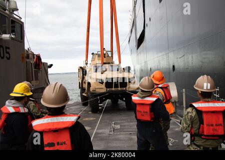 221005-N-DK042-1105 KUSHIRO PORT, Japan (5. Oktober 2022) Matrosen des Amphibious Construction Bataillon (ACB) 1 und des Navy Cargo Handling Bataillon (NCHB) 1, als Teil des Navy Support Elements zur Unterstützung der Operation Resolute Dragon 22, Senken Sie ein Joint Light Tactical Vehicle mit Linien auf das Deck eines verbesserten Marine-Lighterage-Systems (INLS) während des Kranbetriebs ab, während es bei USNS Dahl (T-AKR 312) im Kushiro Port, Japan, am 5. Oktober 2022 festgemacht wurde. USS Benfold (DDG 65), USNS Dahl (T-AKR 312) und USNS Sacagawea (T-AKE 2) nehmen an der gemeinsamen bilateralen Integration mit der III Marine Expedition Teil Stockfoto