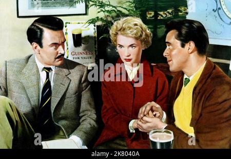 Donald Sinden, Muriel Pavlow & Dirk Bogarde Film: Doctor At Large (1957) Charaktere: Benskin,Joy Gibson & Dr. Simon Sparrow Regie: Ralph Thomas 29. April 1957 **WARNUNG** Dieses Foto ist nur für redaktionelle Zwecke bestimmt und unterliegt dem Copyright der RANK-ORGANISATION und/oder des Fotografen, der von der Film- oder Produktionsfirma beauftragt wurde und darf nur von Publikationen im Zusammenhang mit der Bewerbung des oben genannten Films reproduziert werden. Eine obligatorische Gutschrift für DIE ORGANISATION „RANK“ ist erforderlich. Der Fotograf sollte auch bei Bekanntwerden des Fotos gutgeschrieben werden. Ohne schriftliche Genehmigung der Fil kann keine kommerzielle Nutzung gewährt werden Stockfoto