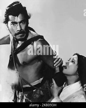 Toshiro Mifune & Machiko Kyo Film: Rashomon, In The Woods (1950) Charaktere: Tajomaru & Masako Kanazawa Regie: Akira Kurosawa 25. August 1950 **WARNUNG** Dieses Foto ist nur für redaktionelle Verwendung bestimmt und unterliegt dem Copyright von RKO und/oder des Fotografen, der von der Film- oder Produktionsfirma beauftragt wurde, und kann nur durch Publikationen im Zusammenhang mit der Bewerbung des oben genannten Films reproduziert werden. Eine obligatorische Gutschrift an RKO ist erforderlich. Der Fotograf sollte auch bei Bekanntwerden des Fotos gutgeschrieben werden. Ohne schriftliche Genehmigung der Film Company kann keine kommerzielle Nutzung gewährt werden. Stockfoto