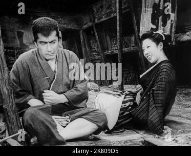 Toshiro Mifune & Kyoko Kawaga Film: The Lower Depths; Donzoko (1959) Regie: Akira Kurosawa 17. September 1957 **WARNUNG** Dieses Foto ist nur für redaktionelle Verwendung bestimmt und unterliegt dem Copyright der TOHO COMPANY und/oder des Fotografen, der von der Film- oder Produktionsfirma beauftragt wurde, und kann nur durch Publikationen im Zusammenhang mit der Bewerbung des oben genannten Films reproduziert werden. Eine obligatorische Gutschrift an DAS UNTERNEHMEN TOHO ist erforderlich. Der Fotograf sollte auch bei Bekanntwerden des Fotos gutgeschrieben werden. Ohne schriftliche Genehmigung der Film Company kann keine kommerzielle Nutzung gewährt werden. Stockfoto