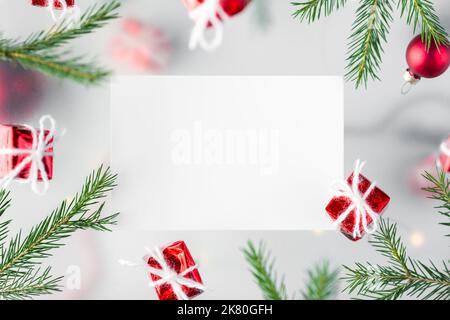 Neujahrshintergrund. Geschenke in rotem Geschenkpapier und Christbaumzweigen im mehrschichtigen Design, auf weißem Hintergrund. Hochwertige Fotos Stockfoto
