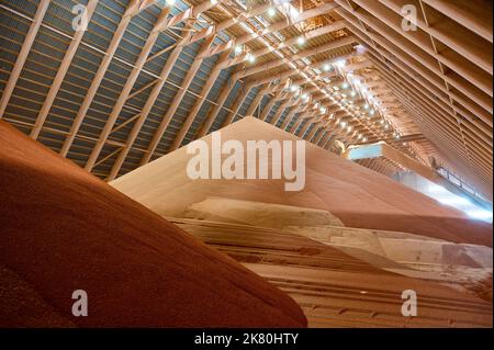 Gießen von roten Phosphatdüngern auf Stapel im Lagerhaus Stockfoto