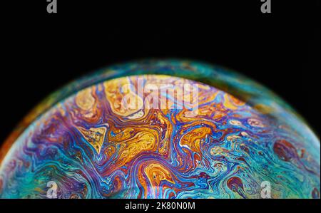 Virtual Reality Raum mit abstrakten multicolor psychedelischen Planeten. Nahaufnahme Seifenblase wie ein außerirdischer Planet auf schwarzem Hintergrund Stockfoto