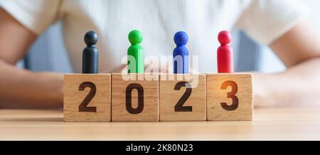 Bunte Holzmenschen mit 2023-Jahres-Blöcken auf der Tabellefür vielfältige, multikulturelle, multirassische, Gleichheits- und Rassismus-Konzepte Stockfoto