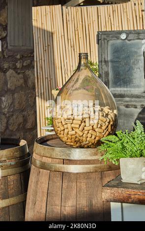 Holzweinfass und Glasflasche mit Weinkorken, Dekoration und Inneneinrichtung Stockfoto