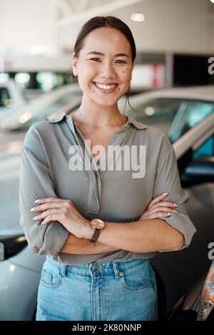 Dies ist mein erster großer Kauf. Eine junge Frau, die neben dem Auto steht, shes zu kaufen. Stockfoto