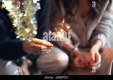 Wunderkerzen in den Händen von Mädchen zu Weihnachten oder Neujahr. Vorderansicht. Stockfoto