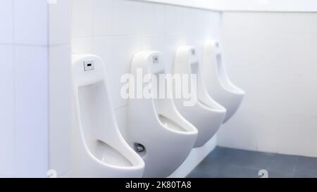 Öffentliche Toilette sauber, moderne weiße Fliesen, Urinal. Stockfoto