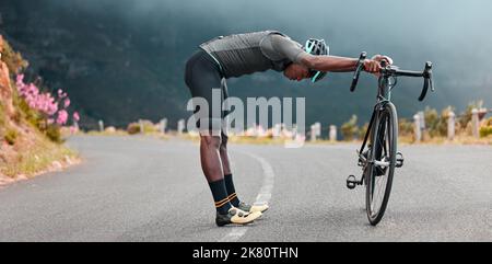 Sportmann, Stretch und Radfahren Pause entlang der Bergroute durch Radfahrer während der Fitness, Bewegung und Morgen Herz ruhen. Stretching, Fahrrad und Stockfoto