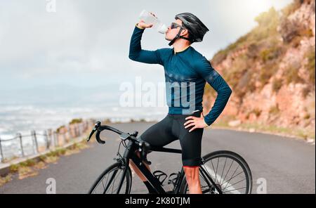 Radfahrer, Trinkwasser oder Fitness-Pause auf der Straße beim Training, Training oder Bewegung im Wettkampfrennen, Gesundheit Wellness. Sportmann, Radsportler oder Stockfoto