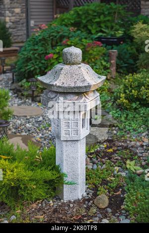 Japanische Pagode auf einem natürlichen Hintergrund. Steinpagode in einem Garten. Niemand, Straßenfoto, selektiver Fokus Stockfoto