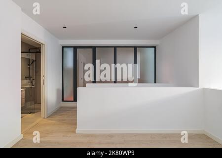 Innenraum der leeren Wohnung mit Tür zum Badezimmer. Weißes und sauberes Zimmer in einem renovierten Apartment Stockfoto