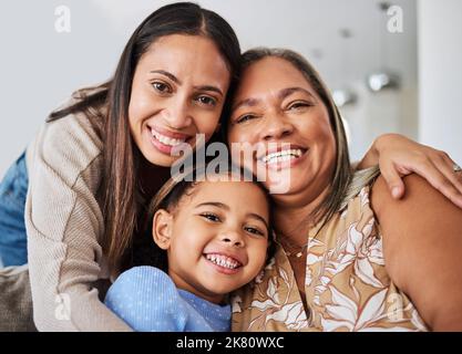 Liebe, Familie und Porträt von Frauen mit mehreren Generationen auf einem Sofa, entspannen, glücklich und sich in einem Wohnzimmer verbinden. Portrait, Mutter, Mädchen und Oma lächeln Stockfoto