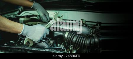 Ein Automechaniker führt eine Autoreparatur in einer Werkstatt durch. Stockfoto