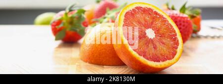 Leckere frische Grapefruit-Scheiben auf Schneidebrett, Bio-Erdbeere für Cocktail Stockfoto