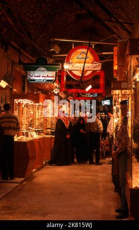 Syrien: Goldgeschäfte im Gold-Souk (Basar) im alten Großen Basar, Aleppo (1997). Der große Basar von Aleppo (auf Arabisch, suq oder suq) wurde zuerst von den ägyptischen Mamelukes, die die Mongolen vertrieben hatten, und dann, nach 1516, von den Türken, die Aleppo in das Osmanische Reich eingliederte, wieder aufgebaut. Während des syrischen Bürgerkrieges, der 2011 begann, erlitten die historischen Suqs von Aleppo schwere Schäden. Aleppo, die zweite Stadt Syriens, ist wahrscheinlich die längste kontinuierlich bewohnte Siedlung der Welt. Sein arabischer Name, Halab, wird in semitischen Texten des dritten Jahrtausends v. Chr. erwähnt. Stockfoto