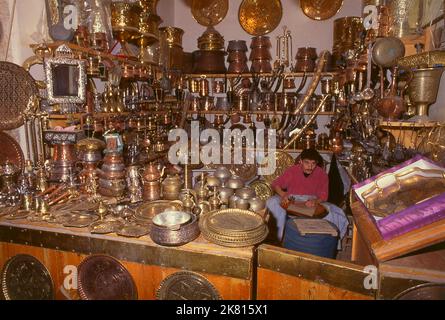 Syrien: Brasswarenhandwerker im alten Großen Basar, Aleppo (1997). Der große Basar von Aleppo (auf Arabisch, suq oder suq) wurde zuerst von den ägyptischen Mamelukes, die die Mongolen vertrieben hatten, und dann, nach 1516, von den Türken, die Aleppo in das Osmanische Reich eingliederte, wieder aufgebaut. Während des syrischen Bürgerkrieges, der 2011 begann, erlitten die historischen Suqs von Aleppo schwere Schäden. Aleppo, die zweite Stadt Syriens, ist wahrscheinlich die längste kontinuierlich bewohnte Siedlung der Welt. Sein arabischer Name, Halab, wird in semitischen Texten des dritten Jahrtausends v. Chr. erwähnt. Stockfoto