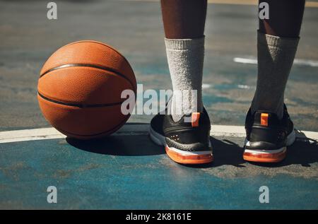 Die Beine von Basketball, Basketballspieler und Sportlern sind auf dem Basketballplatz im Freien hautnah zu sehen. Junger afroamerikanischer Mann, Sport Stockfoto