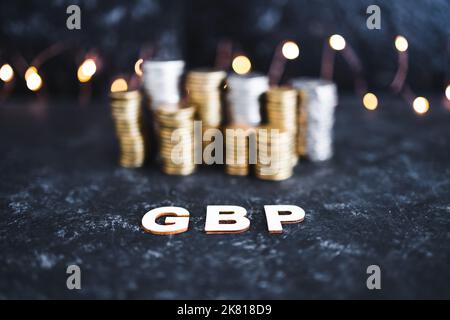 Währungskurskonzeptuelles Bild, britisches Pfund Sterling Text vor Münzstapeln Symbol der Performance an den globalen Aktienmärkten Stockfoto