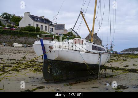 Ein Segelboot liegt bei Ebbe am Strand in der Bretagne Stockfoto