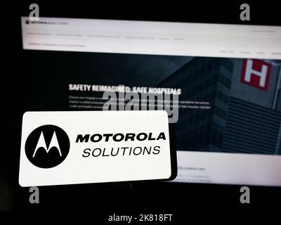 Person, die Mobiltelefon mit dem Logo des US-Unternehmens Motorola Solutions Inc. Auf dem Bildschirm vor der Geschäftswebseite hält. Konzentrieren Sie sich auf die Telefonanzeige. Stockfoto