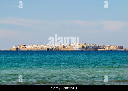 Die Altstadt von Gallipoli, die von einem der Strände im Süden auf die andere Seite der Bucht blicken kann. Apulien (Apulien), Italien. Stockfoto