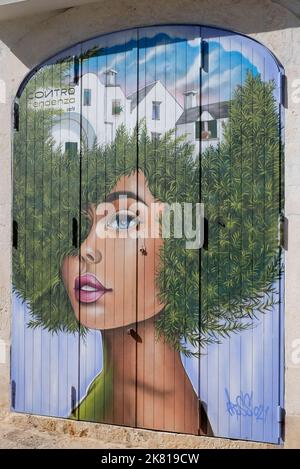 Gemälde von Mädchen mit afro-Stil Frisur auf Rollläden Türen, apulien, italien Stockfoto