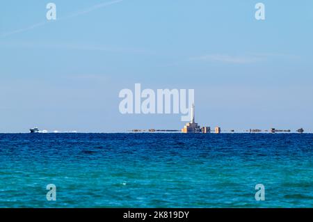 Eine Yacht, die in der Nähe des Leuchtturms Isola Sant'Andrea in einem Fata Morgana-Effekt vor der Westküste des Salento, Apulien (Apulien), Italien, über den Meereshorizont rastet. Stockfoto