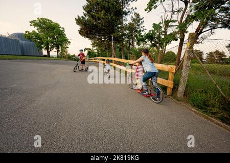 Brno, Tschechische Republik - 21. Mai 2022: Mutter mit drei Kindern fährt im Laufrad ohne Pedale. Stockfoto